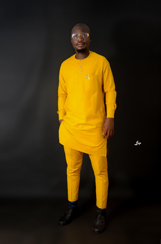 Saheed Alabi smiling in a yellow outfit